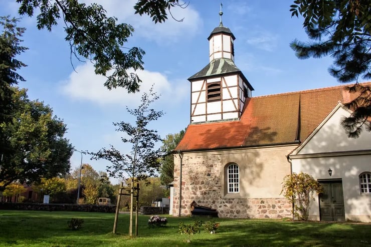 Historische Dorfkirche in Blankenfelde-Mahlow, umgeben von Grünflächen und Bäumen – Glasfaser-Ausbau mit über 120 aktivierten Hausanschlüssen im Ort